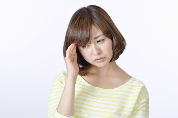 熱中症による頭痛に悩む女性